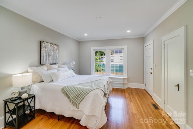 bedroom with hardwood / wood-style flooring, a closet, and crown molding