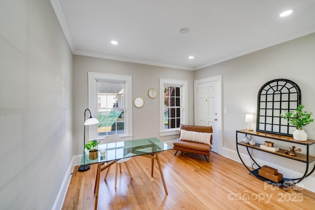 living area featuring light wood-type flooring and crown molding