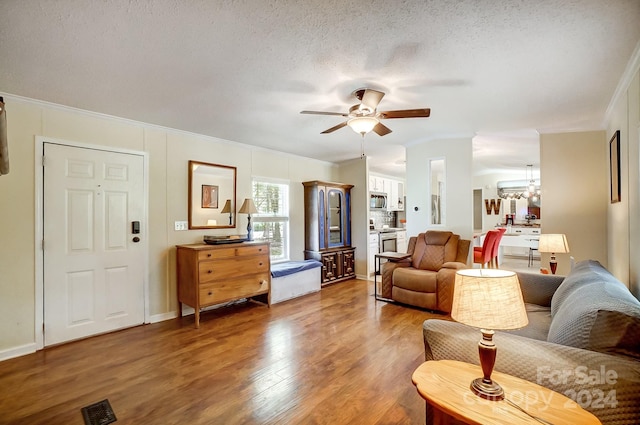 living room featuring crown molding, a textured ceiling, ceiling fan with notable chandelier, and hardwood / wood-style floors