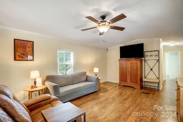 living room featuring ceiling fan, crown molding, vaulted ceiling, and light hardwood / wood-style flooring