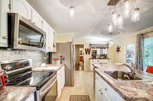 kitchen featuring lofted ceiling, white cabinets, hanging light fixtures, appliances with stainless steel finishes, and sink