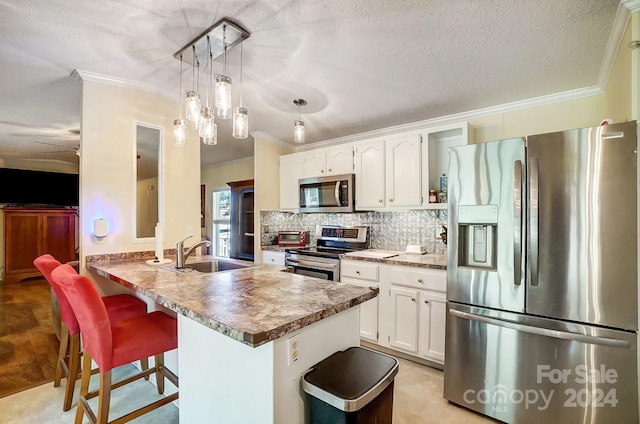 kitchen featuring kitchen peninsula, sink, a breakfast bar, white cabinets, and appliances with stainless steel finishes