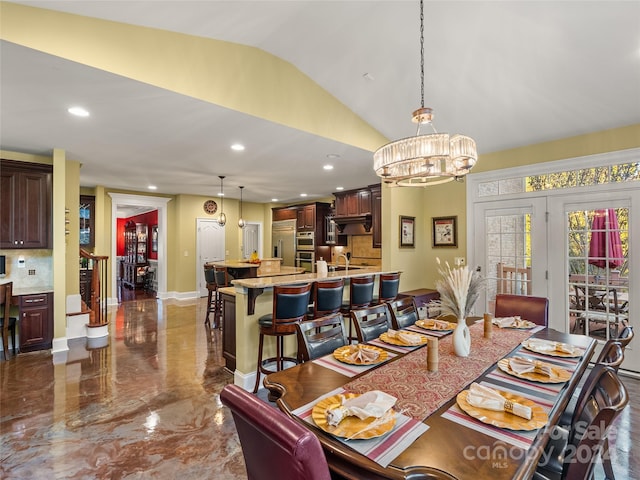 dining room with an inviting chandelier, sink, and vaulted ceiling