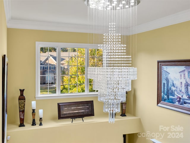 interior details with crown molding and a chandelier