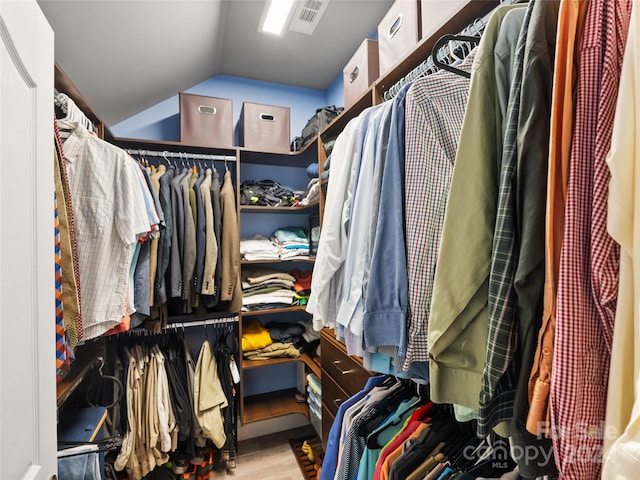 walk in closet featuring vaulted ceiling and light wood-type flooring