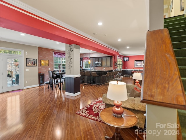 living room with wood-type flooring and ornamental molding