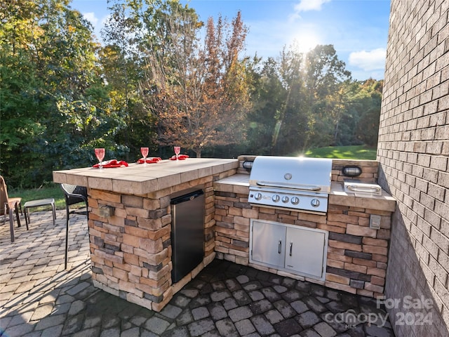 view of patio / terrace featuring grilling area, a bar, and exterior kitchen