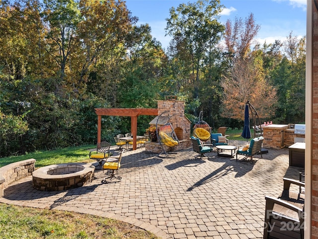 view of patio / terrace featuring area for grilling, exterior fireplace, and an outdoor fire pit