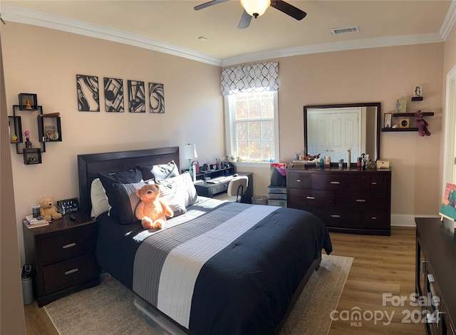 bedroom featuring ceiling fan, ornamental molding, and hardwood / wood-style flooring