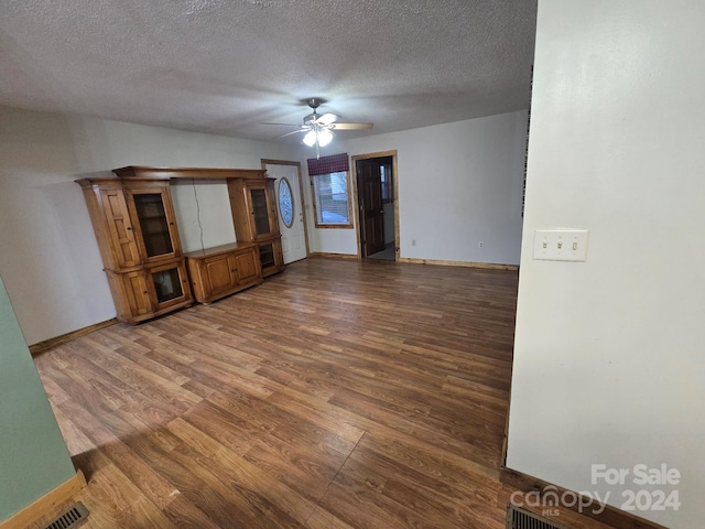 spare room with a textured ceiling, hardwood / wood-style flooring, and ceiling fan