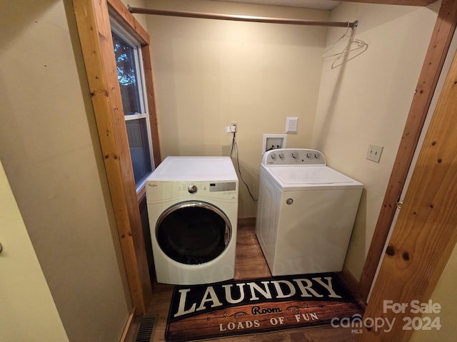 clothes washing area with dark hardwood / wood-style floors and independent washer and dryer