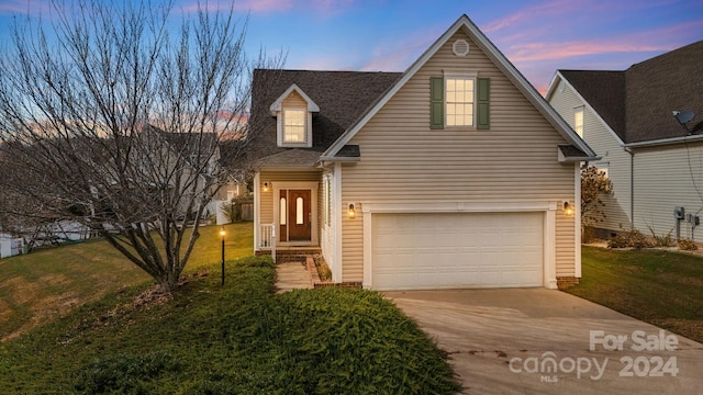 cape cod home featuring a yard and a garage