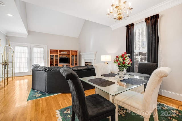 dining room featuring ornamental molding, an inviting chandelier, hardwood / wood-style floors, and vaulted ceiling