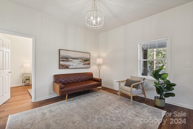 living area with an inviting chandelier and hardwood / wood-style floors