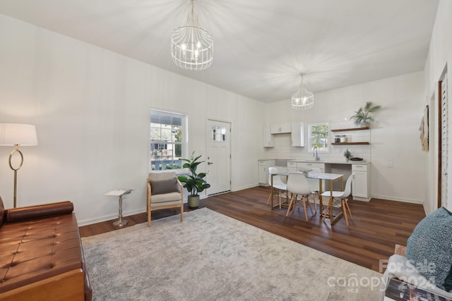 dining area featuring sink, an inviting chandelier, and dark hardwood / wood-style floors