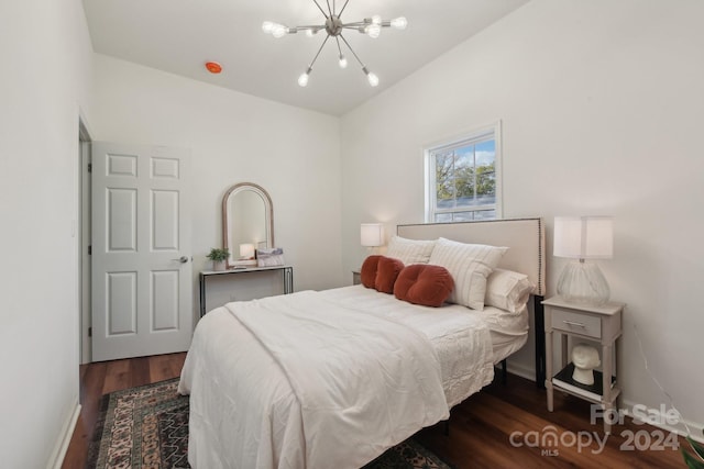 bedroom featuring an inviting chandelier and dark hardwood / wood-style flooring