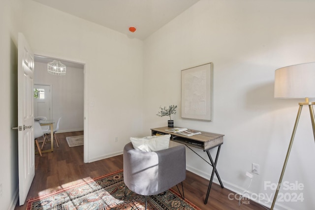 office area with dark wood-type flooring, vaulted ceiling, and an inviting chandelier