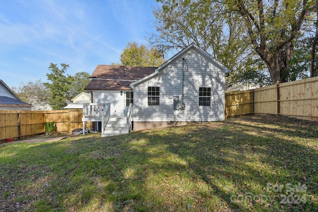 rear view of property featuring a lawn