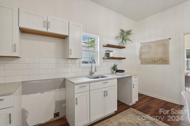 kitchen featuring decorative backsplash, white cabinetry, sink, and dark hardwood / wood-style floors