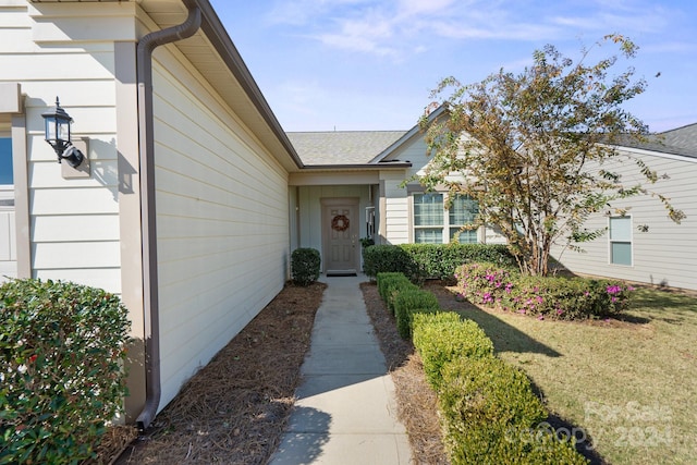 view of exterior entry with a yard