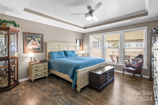 bedroom featuring ceiling fan, a tray ceiling, ornamental molding, and dark hardwood / wood-style flooring