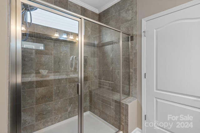 bathroom featuring a shower with door and crown molding