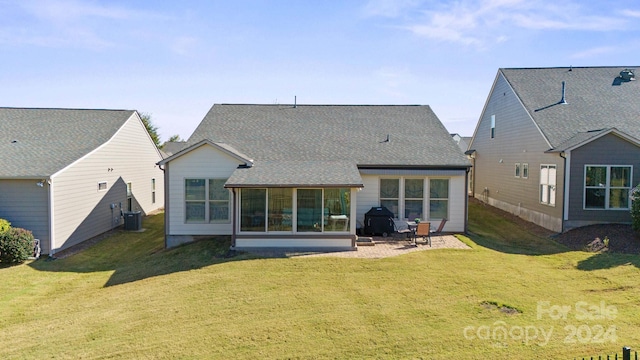 rear view of property featuring a patio and a lawn