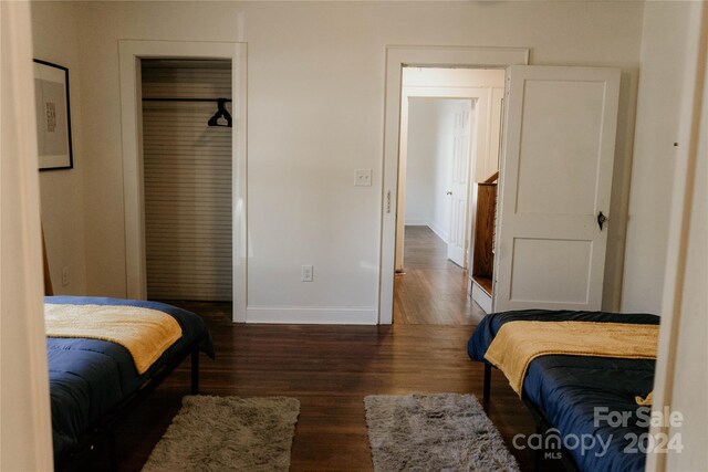 bedroom with dark hardwood / wood-style floors and a closet