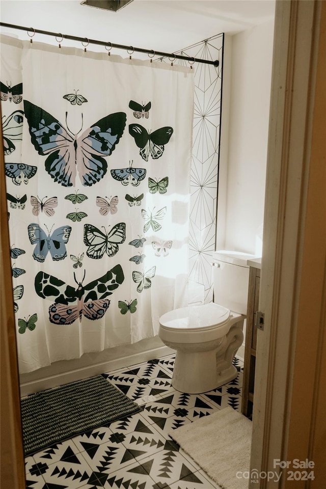 bathroom with toilet and tile patterned flooring