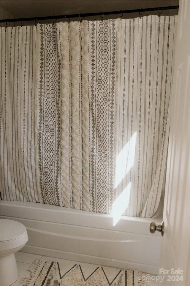 bathroom with shower / bath combo with shower curtain and toilet