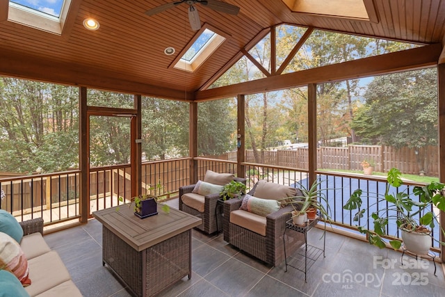 sunroom / solarium with wood ceiling, a wealth of natural light, lofted ceiling with skylight, and ceiling fan