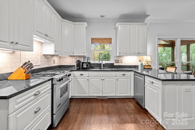 kitchen featuring crown molding, stainless steel range, dark hardwood / wood-style flooring, kitchen peninsula, and white cabinets