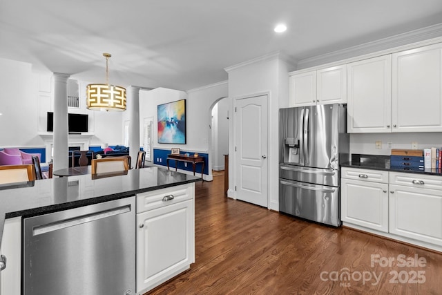 kitchen featuring pendant lighting, stainless steel appliances, dark stone countertops, and white cabinets