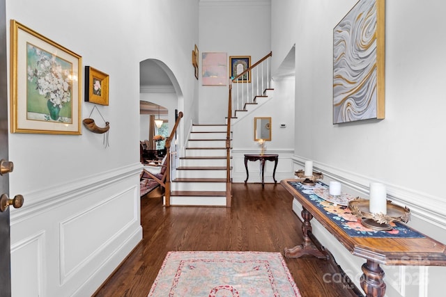 entrance foyer featuring crown molding and dark hardwood / wood-style flooring