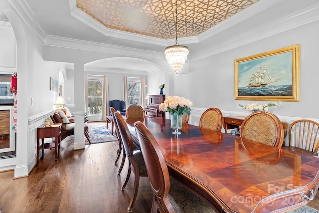 dining room with a tray ceiling, crown molding, dark hardwood / wood-style floors, and a chandelier