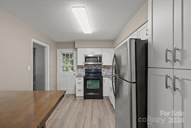 kitchen with tasteful backsplash, white cabinetry, a textured ceiling, light hardwood / wood-style floors, and stainless steel appliances