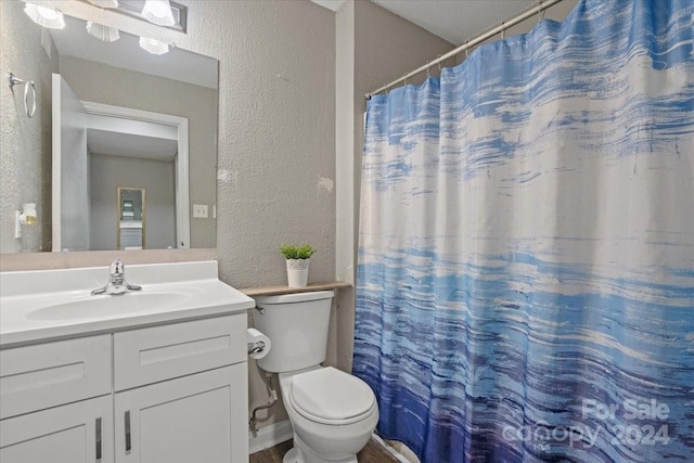 bathroom with vanity, toilet, and walk in shower