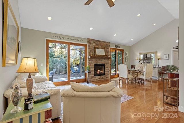 living room with light hardwood / wood-style floors, a fireplace, a healthy amount of sunlight, and ceiling fan