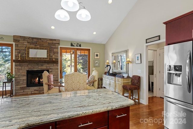 kitchen featuring stainless steel fridge with ice dispenser, decorative light fixtures, dark hardwood / wood-style floors, and a healthy amount of sunlight