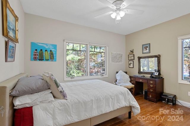 bedroom featuring multiple windows, hardwood / wood-style flooring, and ceiling fan