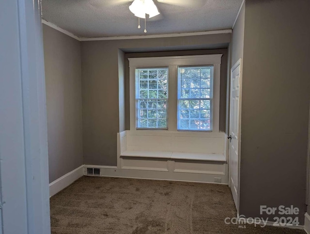 unfurnished room featuring crown molding, carpet floors, and a textured ceiling