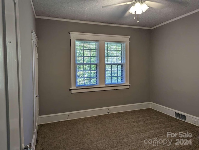 unfurnished room featuring ceiling fan, ornamental molding, a textured ceiling, and dark colored carpet