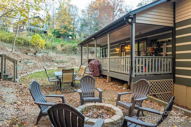 view of patio featuring an outdoor fire pit and a deck