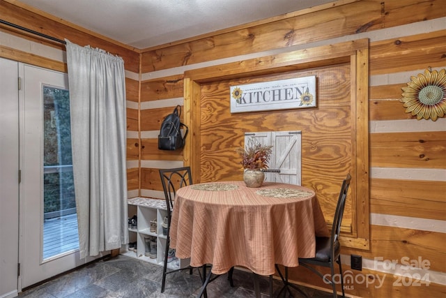 dining area featuring wood walls