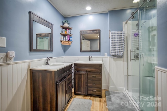 bathroom featuring vanity, hardwood / wood-style floors, a shower with shower door, and a textured ceiling