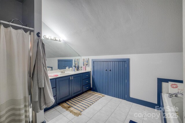 full bath featuring vaulted ceiling, a textured ceiling, a bath, vanity, and tile patterned flooring