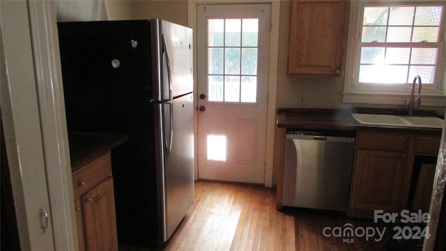 kitchen with stainless steel appliances, sink, and light wood-type flooring