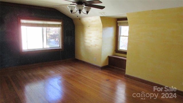 empty room featuring lofted ceiling, dark hardwood / wood-style floors, plenty of natural light, and ceiling fan