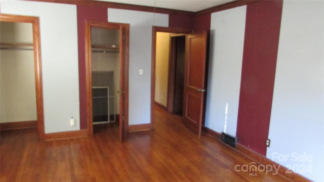 unfurnished bedroom with dark wood-type flooring