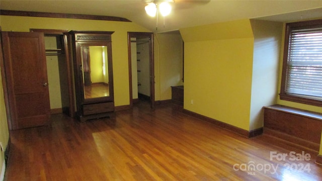 empty room featuring lofted ceiling, hardwood / wood-style flooring, and ceiling fan